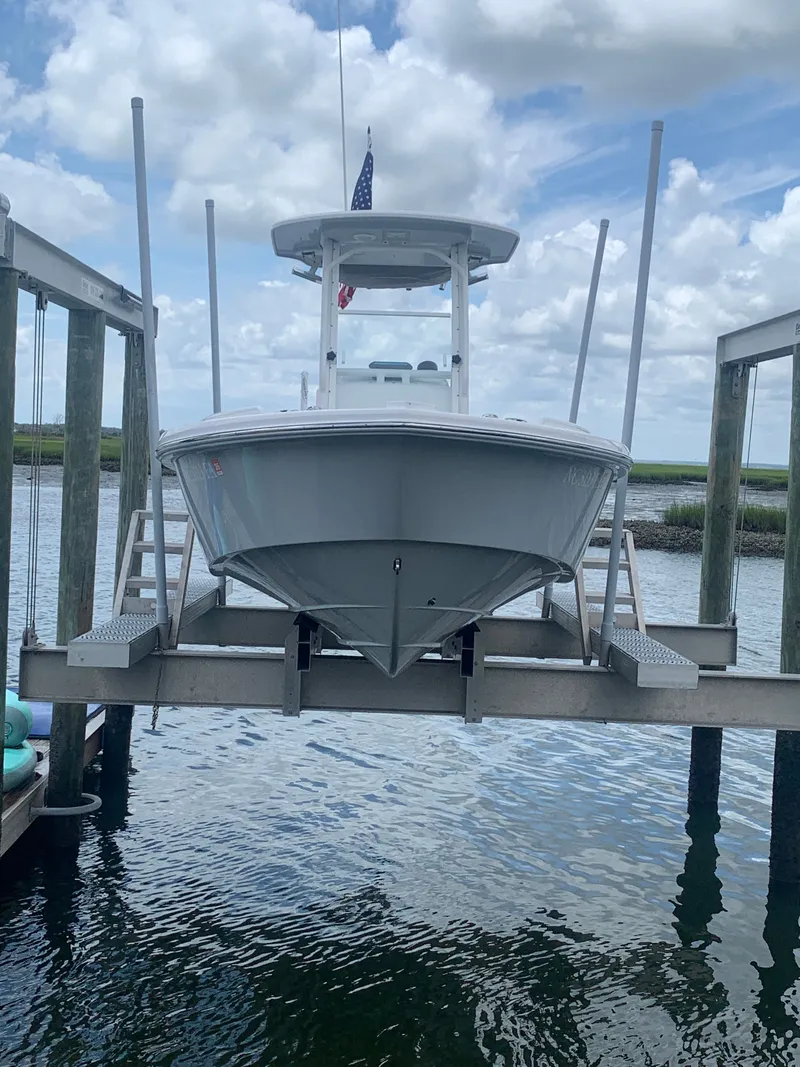 Slide: The Image of A 2023 Everglades 243 Center Console boat is seen on a boat lift above the water. - 46