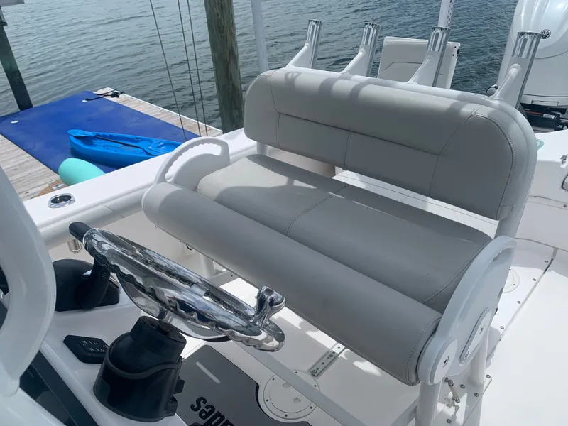 Slide: The Image of The image shows the helm of an Everglades 243 Center Console boat with gray cushioned seats. - 18