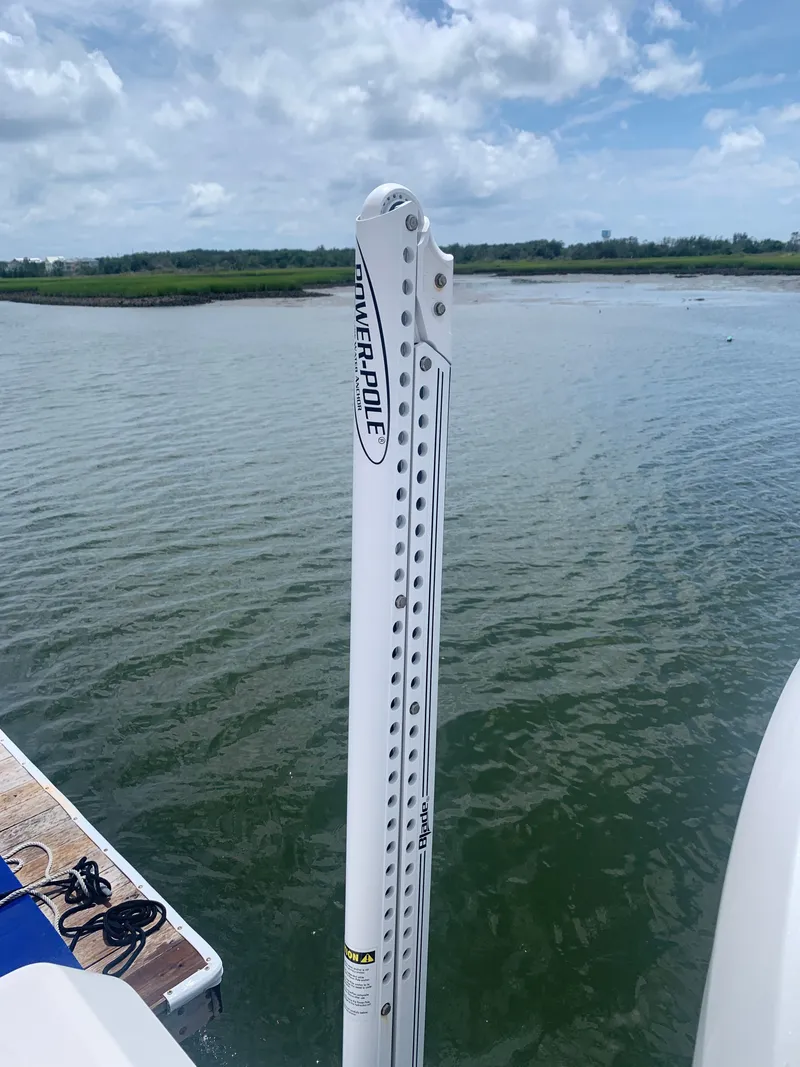 Slide: The Image of A Power-Pole anchor is attached to a boat on calm water. - 11