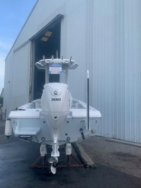 Slide: The Image of A white 2023 Everglades 243 Center Console boat is positioned outside a large warehouse. - 1