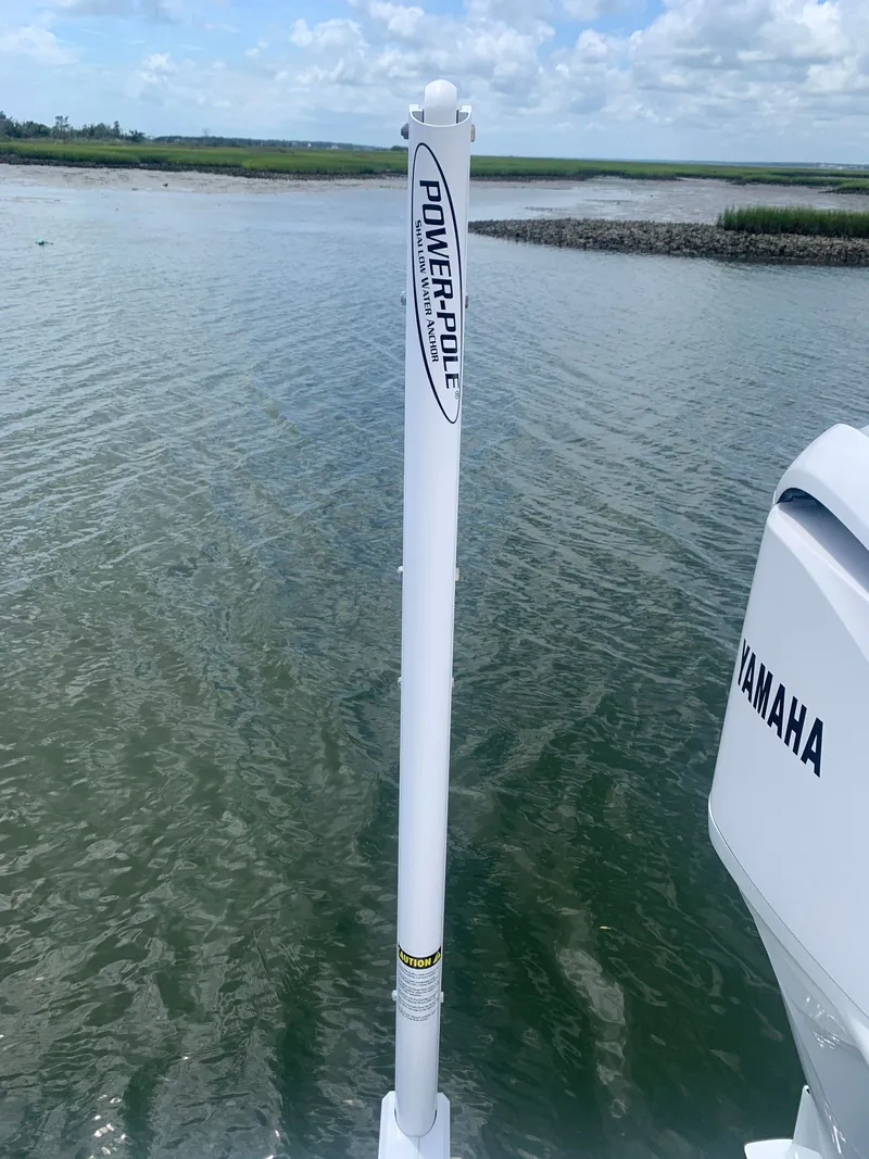 Slide: The Image of A Power-Pole anchor is mounted at the stern of a boat, with water and shoreline in the background. - 37