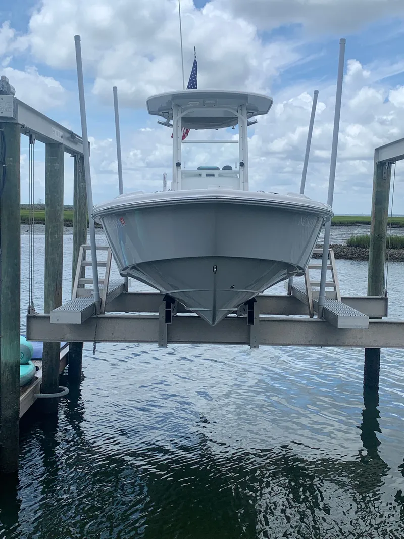 Slide: The Image of A 2023 Everglades 243 Center Console boat is seen on a boat lift above the water. - 45