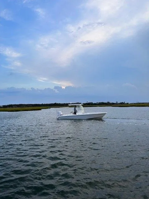 Slide: The Image of An Everglades 243 Center Console boat cruising on calm waters under a cloudy sky. - 3