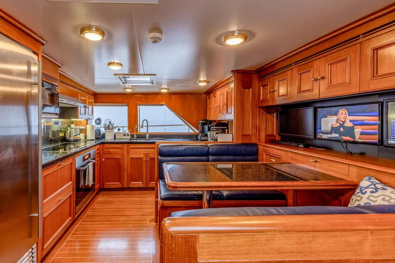 Slide: The Image of Luxurious yacht interior with wooden cabinetry, dining area, and modern kitchen appliances, Holland Jachtbouw 2004. - 49