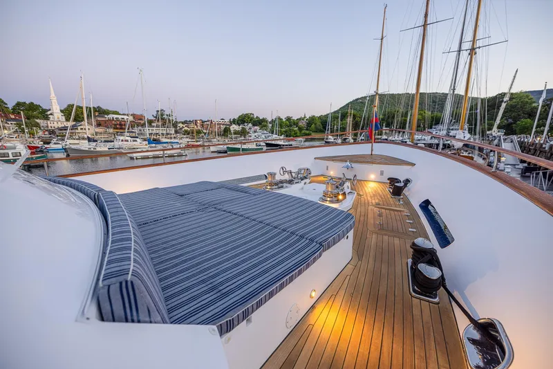Slide: The Image of Luxurious 2004 Holland Jachtbouw Custom yacht deck with striped seating and scenic harbor view. - 23