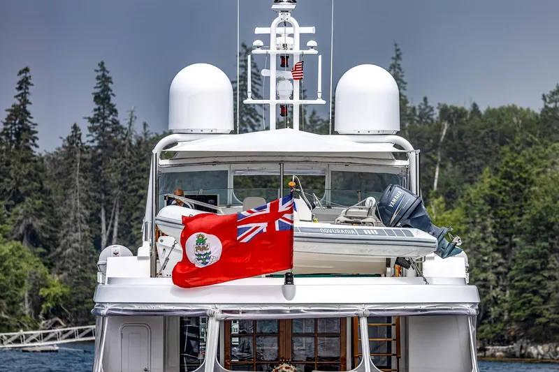Slide: The Image of Luxury 2004 Holland Jachtbouw Custom yacht with flag, surrounded by lush forest backdrop. - 74