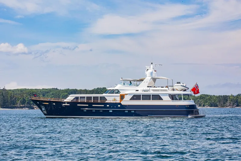 Slide: The Image of Luxurious 2004 Holland Jachtbouw Custom yacht cruising on serene waters under a clear sky. - 86
