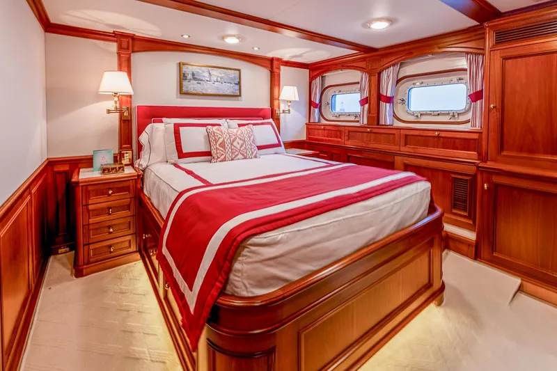 Slide: The Image of Luxurious yacht bedroom with elegant wood paneling, red accents, and porthole windows, Holland Jachtbouw 2004. - 47