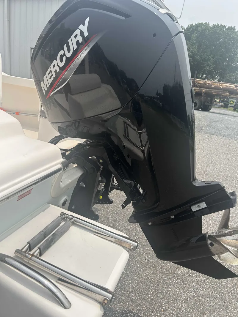 Slide: The Image of A Mercury outboard motor is mounted on a white boat parked in a lot. - 7