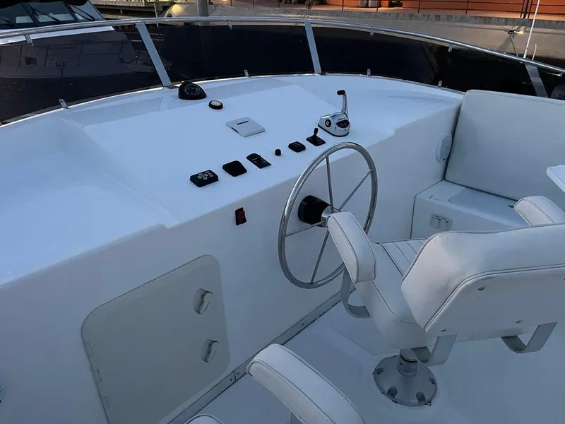 Slide: The Image of The image shows a boat's helm with a white steering wheel and a seat. - 57