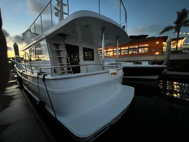 Slide: The Image of A modern boat docked, featuring a sleek white hull and spacious aft platform. - 50