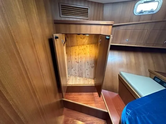 Slide: The Image of Wooden interior of 2025 Bracewell 41 boat with open storage compartment. - 14