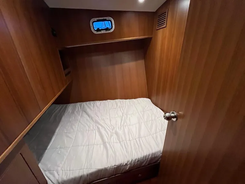 Slide: The Image of Cozy cabin interior of 2025 Bracewell 41 yacht with wooden paneling and small window. - 21