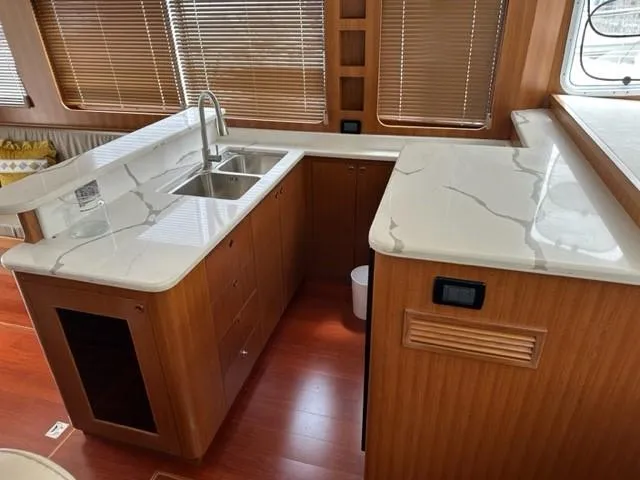 Slide: The Image of Modern kitchen in 2025 Bracewell 41 yacht with sleek countertops and wooden cabinetry. - 16