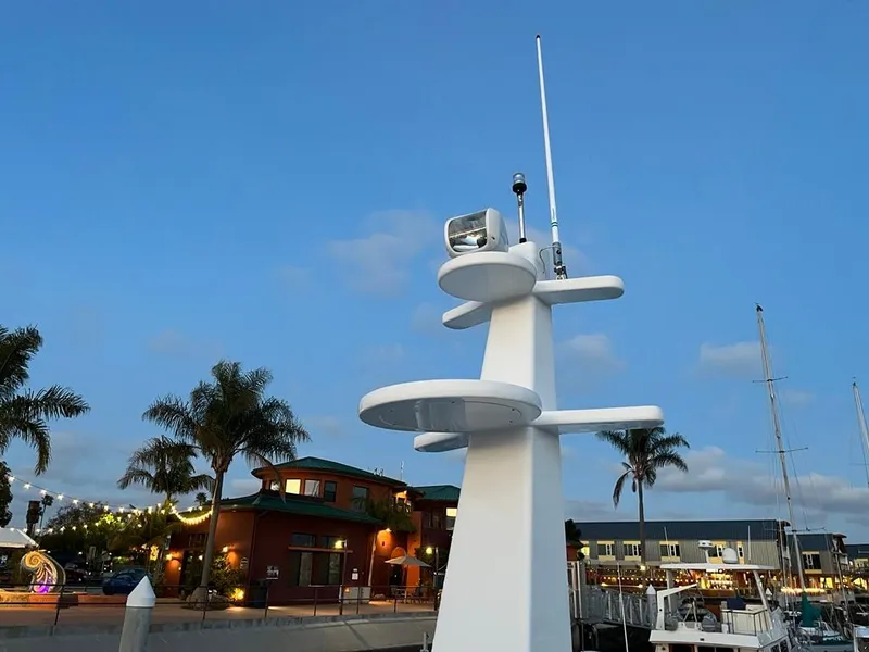 Slide: The Image of A modern boat with a tall mast and radar, docked in a harbor at sunset. - 60