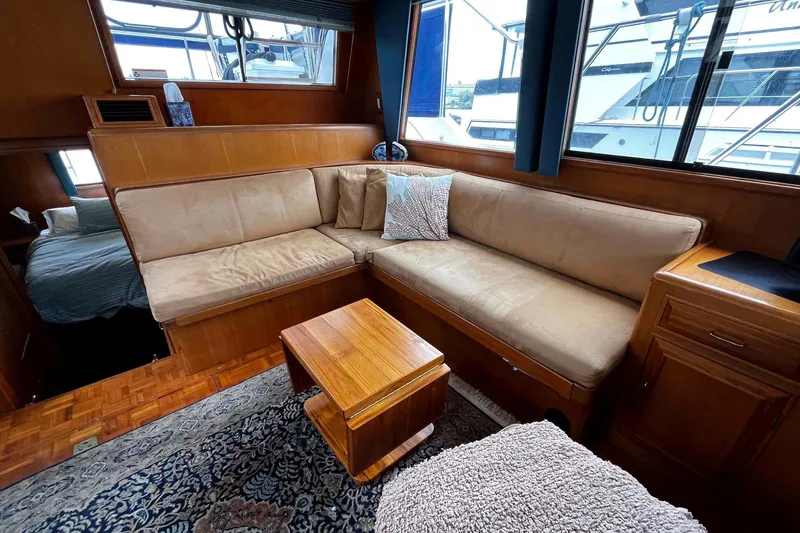 Slide: The Image of Interior of 1997 Ocean Alexander 440 Sundeck CPMY with cozy seating and wooden accents. - 14