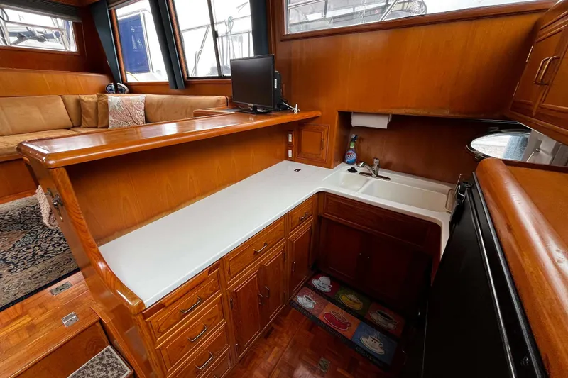 Slide: The Image of Interior of 1997 Ocean Alexander 440 Sundeck CPMY with wooden cabinetry and cozy seating area. - 16