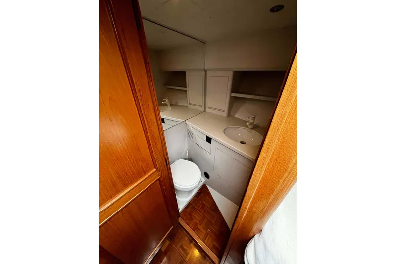 Slide: The Image of Bathroom interior of 1997 Ocean Alexander 440 Sundeck CPMY yacht, featuring wooden cabinetry and modern fixtures. - 21