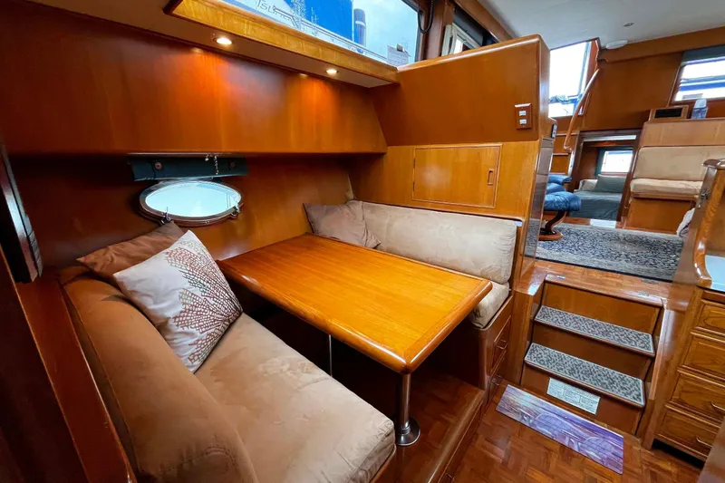 Slide: The Image of Luxurious 1997 Ocean Alexander 440 Sundeck CPMY interior with cozy dining area and wooden finishes. - 19