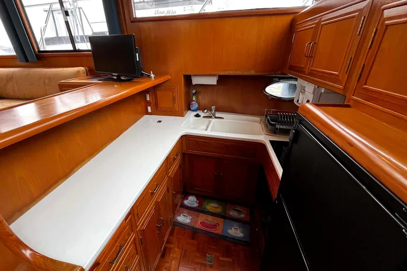 Slide: The Image of Luxurious 1997 Ocean Alexander 440 Sundeck CPMY yacht kitchen with wood cabinetry and modern amenities. - 17