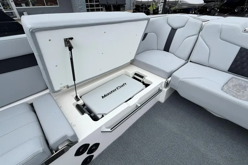 Slide: The Image of 2024 MasterCraft XT25 boat interior with open storage compartment and seating. - 32