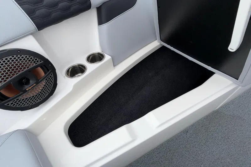 Slide: The Image of 2024 MasterCraft XT25 boat interior with speaker, cup holders, and storage compartment. - 6
