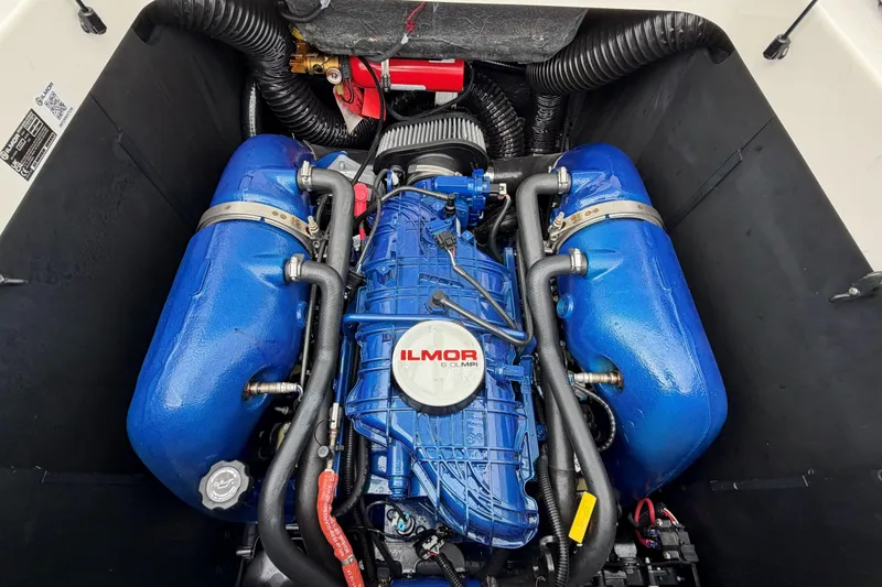 Slide: The Image of 2024 MasterCraft XT25 engine compartment featuring Ilmor marine engine components. - 28