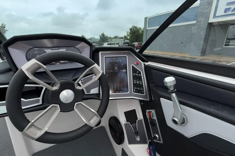 Slide: The Image of 2024 MasterCraft XT25 boat dashboard with modern steering wheel and control panel. - 18