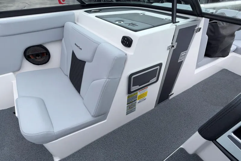 Slide: The Image of 2024 MasterCraft XT25 boat interior with gray seating and storage compartments. - 13