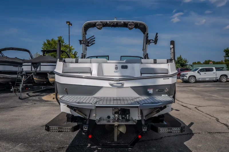 Slide: The Image of 2024 MasterCraft XT25 boat rear view in a parking lot under clear skies. - 4