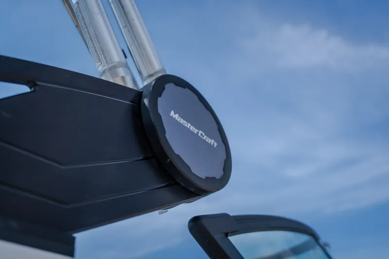 Slide: The Image of Close-up of 2024 MasterCraft XT25 boat detail against blue sky. - 9
