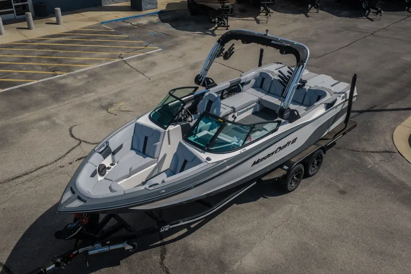 Slide: The Image of 2024 MasterCraft XT25 boat on trailer, parked in a lot, showcasing sleek design and modern features. - 23