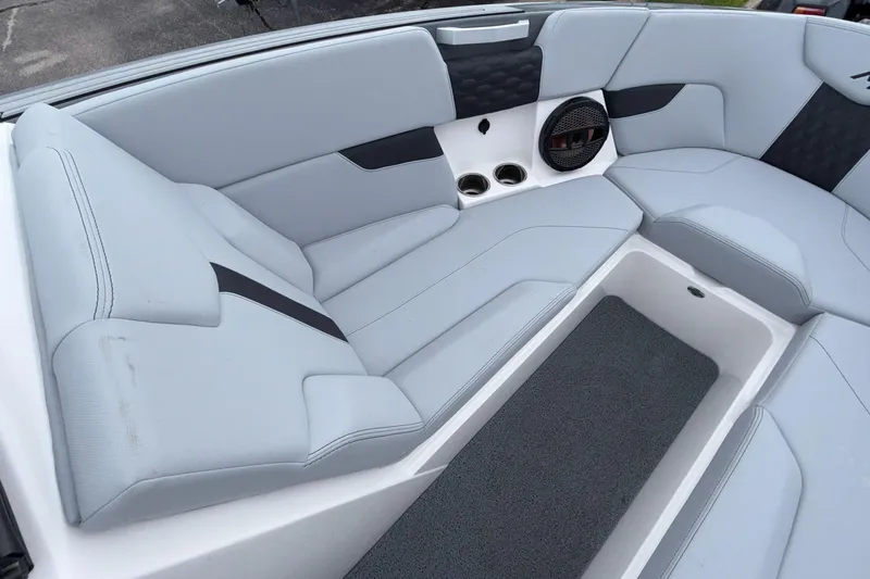 Slide: The Image of 2024 MasterCraft XT25 boat interior with sleek seating and integrated speaker system. - 11