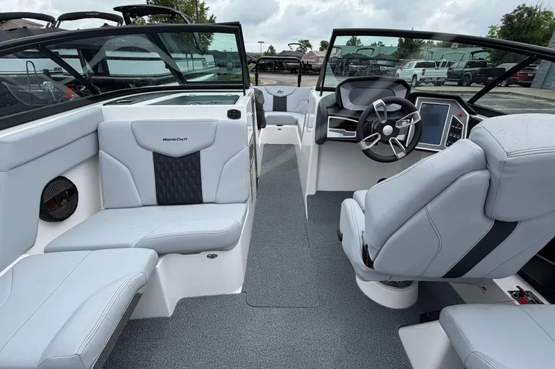 Slide: The Image of 2024 MasterCraft XT25 boat interior with modern seating and steering console. - 37