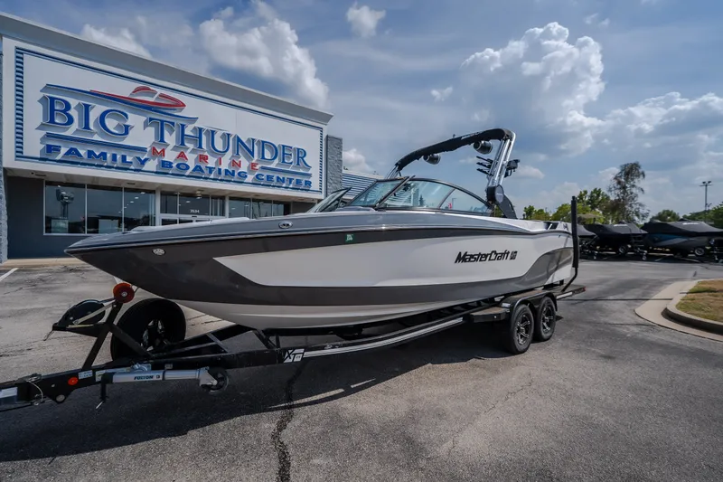 Slide: The Image of 2024 MasterCraft XT25 boat on trailer at Big Thunder Marine dealership. - 1