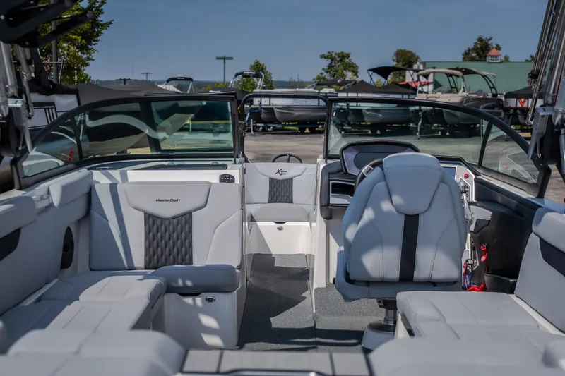Slide: The Image of 2024 MasterCraft XT25 boat interior with sleek seating and modern dashboard design. - 12