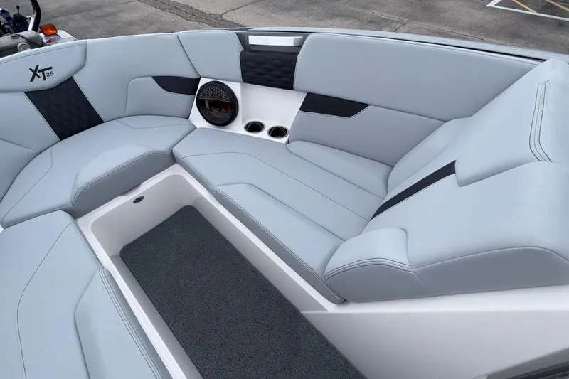 Slide: The Image of 2024 MasterCraft XT25 boat interior with sleek seating and integrated speaker system. - 8