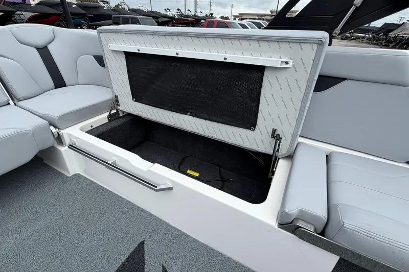 Slide: The Image of 2024 MasterCraft XT25 boat interior storage compartment with open seat and sleek design. - 30