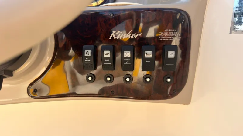 Slide: The Image of Close-up of a Rinker 192 Captiva Bowrider dashboard with various switches. - 22