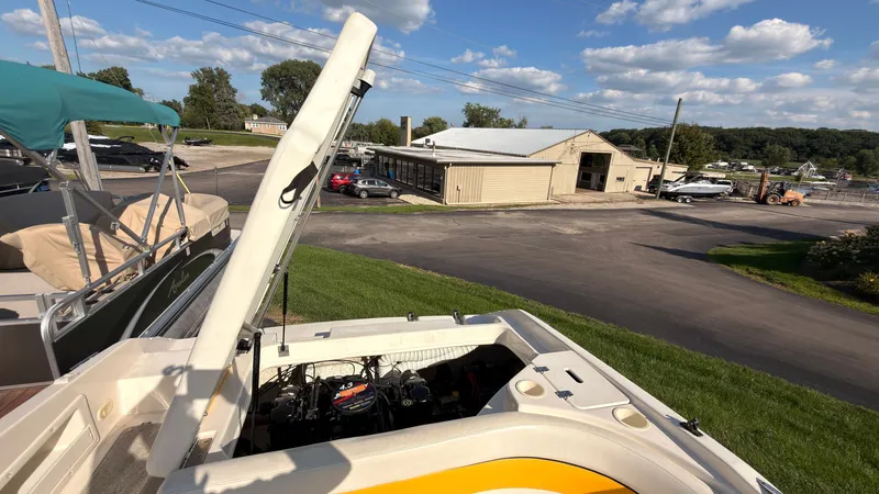 Slide: The Image of An open engine compartment of a 2002 Rinker 192 Captiva Bowrider with a view of a boatyard. - 14