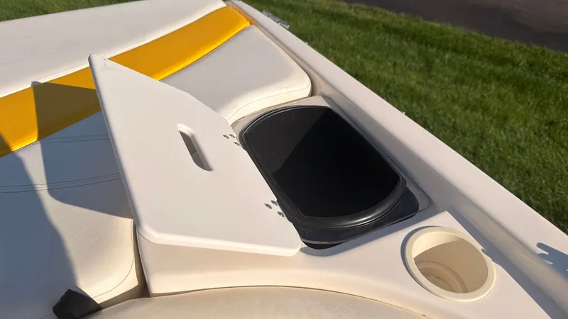 Slide: The Image of An open storage compartment on a boat with yellow and white upholstery. - 13