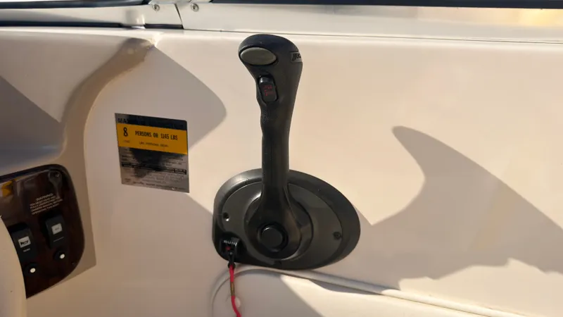 Slide: The Image of Close-up of a black throttle lever on a boat, surrounded by beige surfaces. - 23