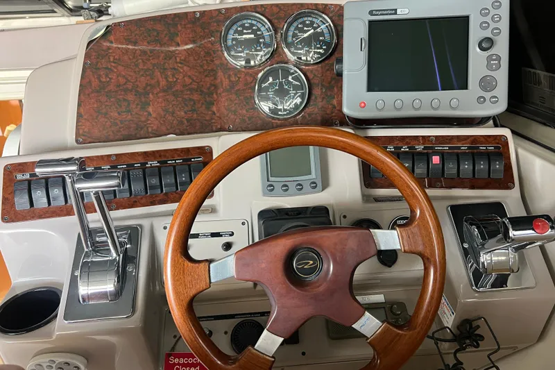 Slide: The Image of Dashboard of a 2000 Regal Commodore 4160 boat with wooden steering wheel and navigation controls. - 15