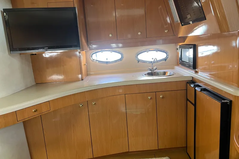 Slide: The Image of Interior of 2000 Regal Commodore 4160 yacht kitchen with wood cabinets, sink, and appliances. - 17