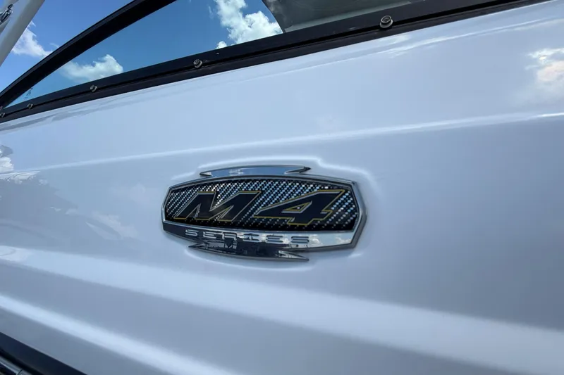 Slide: The Image of 2024 Monterey M4 boat emblem on sleek white exterior under blue sky. - 34