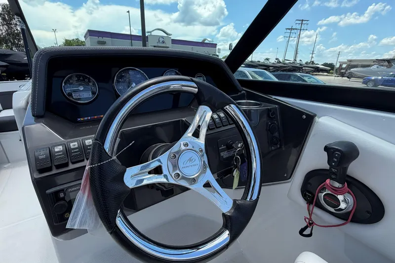 Slide: The Image of 2024 Monterey M4 boat dashboard with steering wheel and control panel under a blue sky. - 15
