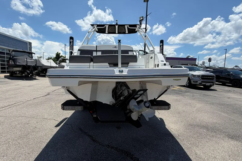 Slide: The Image of 2024 Monterey M4 boat, rear view, parked outdoors under a blue sky with clouds. - 41