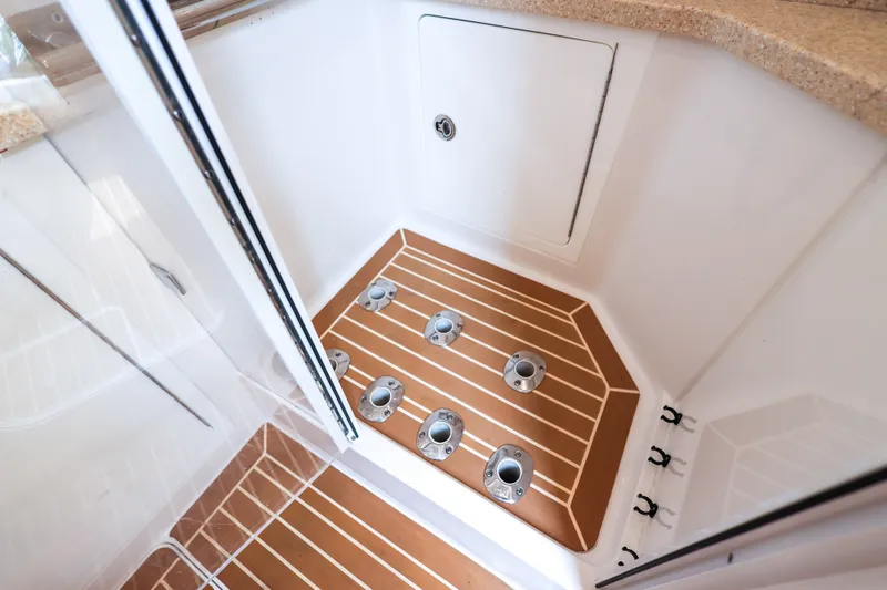 Slide: The Image of Interior view of 2018 HCB 53 Suenos boat, featuring teak flooring and storage compartment. - 47