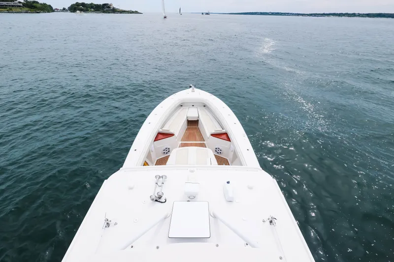 Slide: The Image of 2018 HCB 53 Suenos boat cruising on open water, showcasing sleek design and spacious deck. - 63