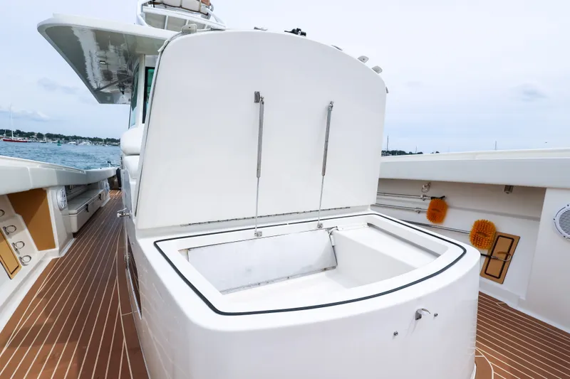 Slide: The Image of 2018 HCB 53 Suenos boat deck with open storage compartment, docked by the water. - 55